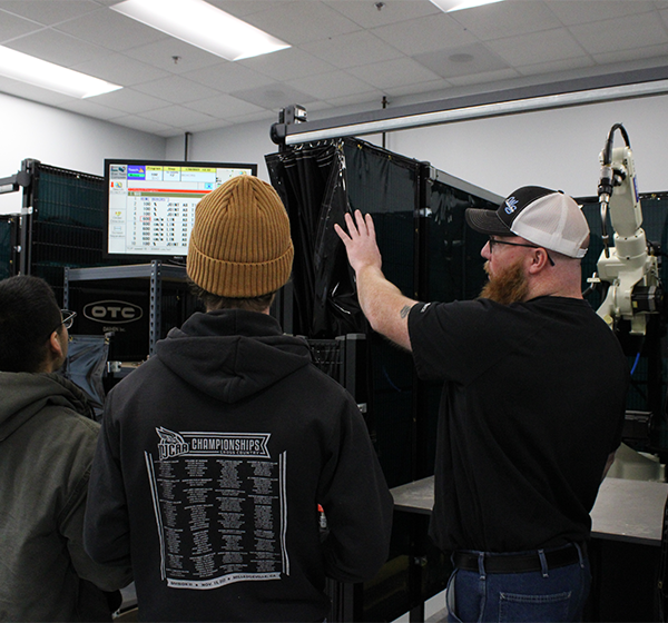 students using robotic welding machines